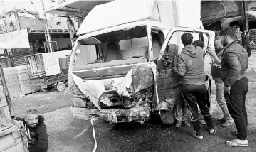  ??  ?? Iraqis inspect the damage the morning after a car bomb attack, in the business district of Hay al-Amel in the west of Baghdad. — AFP photo