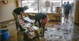  ?? RALPH BARRERA / AMERICAN-STATESMAN ?? State Farm agent Phillip Adamcik (left) cleans his La Grange office after Hurricane Harvey. La Grange High canceled its first week of classes.