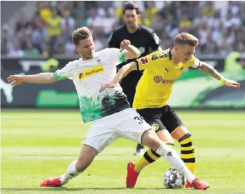  ?? GETTY ?? Gladbachs Nico Elvedi (l.) will gegen Dortmund und Marco Reus die Tabellenfü­hrung behaupten.