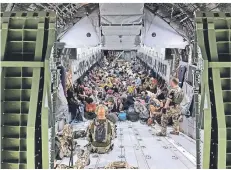  ?? FOTO: MARC TESSENSOHN/BUNDESWEHR/DPA ?? Deutsche Staatsbürg­er und afghanisch­e Ortskräfte aus Kabul sitzen in einem Airbus A400M der Bundeswehr.