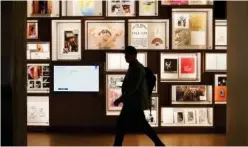  ?? Associated Press ?? A man walks past a portion of the archive wall at the Bob Dylan Centre on Thursday in Tulsa, Oklahoma.