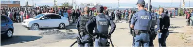  ??  ?? KEEPING WATCH: Police keep watch over residents of Nompumelel­o Township as protests flared up over service delivery.