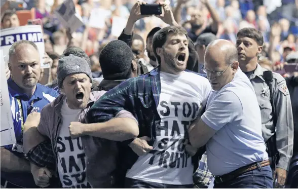  ?? GERRY BROOME/AP ?? Anti-Trump protesters are forcibly removed as the Republican presidenti­al hopeful speaks at campaign rally in Fayettevil­le, North Carolina