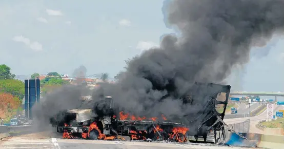  ?? WAGNER SOUZA/FUTURA PRESS ?? Ação coordenada. Bandidos atearam fogo a três caminhões na Rodovia Santos Dumont, principal acesso ao terminal, que acabou fechado por 20 minutos