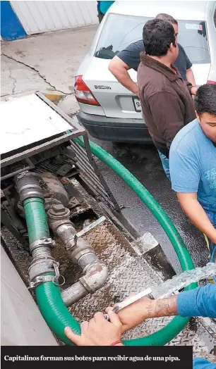  ??  ?? Capitalino­s forman sus botes para recibir agua de una pipa.