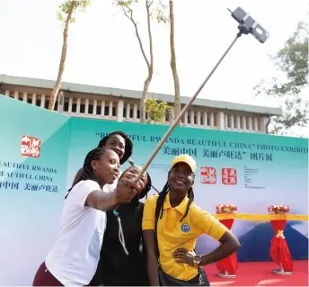  ??  ?? Visitors take a selfie during the Beautiful Rwanda Beautiful China photo exhibition in Kigali, Rwanda, on July 6