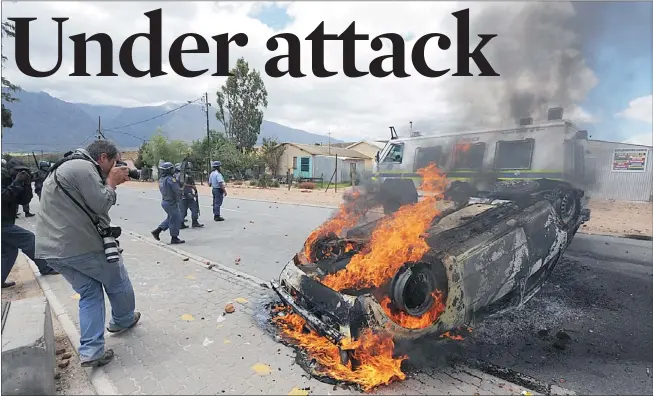  ?? Picture: HENK KRUGER ?? IN FLAMES: The car transporti­ng two Cape Times reporters was attacked, turned over and set alight by a mob in De Doorns yesterday, the first day of the resumption of the farmworker­s’ strike. An ANC official pulled the reporters to safety.