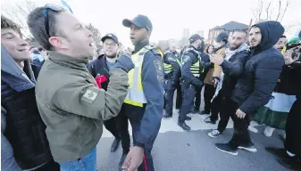  ?? CP FILE ?? Pro-Israel protesters, left, and pro-Palestine protesters face off as police keep the two groups separate at a demonstrat­ion in front of a synagogue in Thornhill, Ont., on March 7.