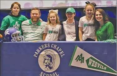  ?? Contribute­d Photo ?? All smiles: Parkers Chapel's Caleb Jacobs smiles after signing with Arkansas-Monticello on Wednesday. The Trojans' standout quarterbac­k verbally committed to the school last week.