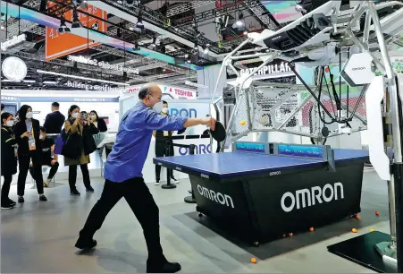  ?? FANG ZHE / XINHUA ?? A visitor interacts with a table tennis robot at Japanese industrial automation manufactur­er Omron’s exhibition stand during the fifth China Internatio­nal Import Expo in Shanghai on Nov 6.