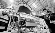  ?? CHEN JIANLI / XINHUA ?? Two workers examine the parts of a new energy vehicle in the welding workshop in Binhai Zone of Tianjin in December.