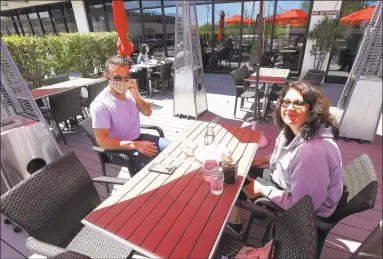  ?? Matthew Brown / Hearst Connecticu­t Media ?? Stavros Begetis, of Stamford, and his mother, Connie Begetis, prepare to enjoy a meal at Tomato Tomato in Stamford on Wednesday. The two were among the first customers to enjoy the return of outdoor dining as businesses in the area begin to reopen following a statewide shutdown in response to the COVID-19 pandemic.