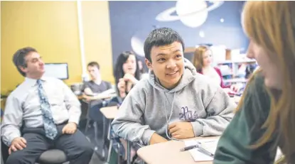  ?? ANDY DUBACK FOR USA TODAY ?? Kun Yan, center, a student from China, talks with a classmate in math class at Newcomb Central School in Newcomb, N. Y.