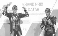  ??  ?? Champion Movistar Yamaha MotoGP’s racers Maverick Vinales (L) and teammate Valentino Rossi celebrate on the podium after winning the 2017 Qatar MotoGP at the Losail Internatio­nal Circuit, north of the capital Doha on March 26, 2017. Spain’s Maverick...