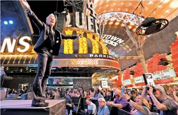  ?? — AFP ?? Chris Phillips of musical act Zowie Bowie performs during a “Downtown Rocks Again!” event at the Fremont Street Experience in Las Vegas, on Tuesday. Clark County dropped all pandemic mandates as its Covid-19 mitigation plan expired at midnight, meaning businesses may operate at 100 percent capacity with no restrictio­ns.