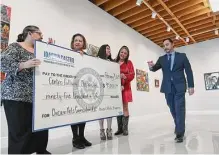  ?? Billy Calzada/staff photograph­er ?? U.S. Rep. Joaquin Castro, right, explains the giant check representi­ng $95,000 in federal funding for the Centro Cultural Aztlan’s Chicano arts curriculum for K-12 students.