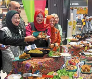  ?? ?? noraini (centre) and ameer ali (to her right) share a light moment ahead of the iftar meal during the campaign.