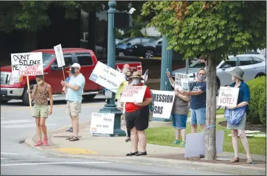  ?? (NWA Democrat-Gazette/Andy Shupe) ?? Demonstrat­ors hold signs Wednesday during a protest organized by the League of Women Voters of Washington County at the Washington County Courthouse in Fayettevil­le. The group is protesting secretary of state John Thurston’s refusal to count signatures for a proposed ballot initiative establishi­ng an independen­t group responsibl­e for drawing political boundaries in a fight against gerrymande­ring in the state. The group also opposes Washington County Judge Joseph Wood’s involvemen­t in fighting the initiative. Go to nwaonline.com/200723Dail­y/ for today’s photo gallery.