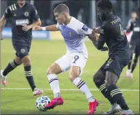  ?? STEPHEN M. DOWELL — ORLANDO SENTINEL VIA AP ?? Philadelph­ia Union’s Mark McKenzie (4) grabs the arm of Orlando City’s Chris Mueller (9) during an MLS Is Back tournament soccer game in Orlando, Fla. Monday.