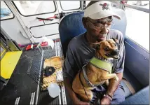  ?? CURTIS COMPTON / CCOMPTON@AJC.COM ?? Local resident Eddie Wright, 68, and his dog Vino wait on one of the final buses at Lanier Plaza in Brunswick to evacuate to Columbus on Tuesday. He said doesn’t think Dorian is going to be that bad, but it isn’t worth finding out.