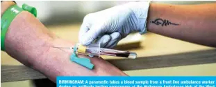  ?? — AFP ?? BIRMINGHAM: A paramedic takes a blood sample from a front line ambulance worker during an antibody testing programme at the Hollymore Ambulance Hub of the West Midlands Ambulance Service in Birmingham.