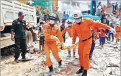  ?? FRESH NEWS ?? Rescue workers recover the body of a victim from the debris of a building after it collapsed in Sihanoukvi­lle, Preah Sihanouk province.
