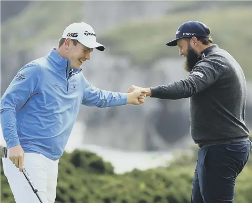  ??  ?? 0 A fist bump between Oban’s Bob Macintyre, left, and Andrew ‘Beef’ Johnston during their first round at The Open at Royal Portrush.