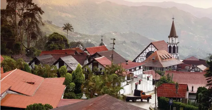  ?? Foto: Urs Flüeler, Mauritius Images ?? Fachwerkhä­user in Südamerika: Das ist die deutsche Siedlung Colonia Tovar in Venezuela, in der Mitte die Dorfkirche San Martin.