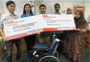  ??  ?? Helpful donation: The Star journalist Ong Han Sean (left) handing over mock cheques to (starting third from left) Mohamad Fauzi, Perumal and other staff from Pusat Penjagaan Kanak-Kanak Terencat Akal Kuantan. Looking on is Tee (second from left).