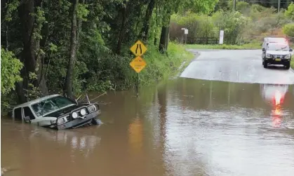  ?? Photograph: NSW SES ?? NSW SES Wyong unit volunteers assist the local community with the dangers associated with driving through flood water. Another rain system is expected to bring wet weather from Wednesday to Friday.