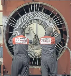  ??  ?? Parsons Peebles technician­s work on a motor rewind job at the group’s base at Rosyth.