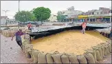  ?? SAMEER SEHGAL/HT PHOTO ?? Workers cover wheat at a market in Amritsar. n