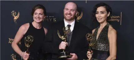  ??  ?? Tara Feldstein Bennett, from left, Chase Paris and Carmen Cuba pose in the press room with the award for outstandin­g casting for a drama series for “Stranger Things”.