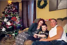  ?? THE CANADIAN PRESS/CHRIS YOUNG ?? Evan Leversage, centre, sits in his family home with mother Nicole Wellwood, left, and father Travis Leversage before watching a Christmas Parade in St. George, Ont., in October 2015.