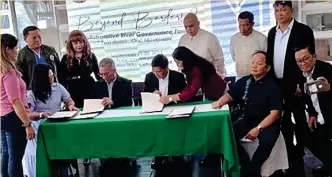  ?? ?? Mandaue City Mayor Jonas Cortes (seated, second from left) and Cebu City Mayor Michael Rama (seated, third from right) sign a memorandum of agreement and pledge of river stewardshi­p, committing to lay down action plans for the rehabilita­tion of the Butuanon and Mahiga Rivers that border the two localities. (Cebu City PIO)