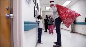  ??  ?? SORPRESA. Con un gorro de Navidad y una bolsa roja, el expresiden­te de Estados Unidos le alegró la Navidad a los niños enfermos con juguetes.