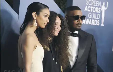  ?? JORDAN STRAUSS, INVISION VIA AP ?? Actor-singer Jamie Foxx, right, poses with his daughters Corinne Foxx, left, and Anelise Bishop at the Screen Actors Guild Awards in Los Angeles last year. Jamie Foxx talks about his kids and his career in his new memoir, released Tuesday.