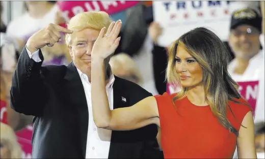  ?? CHRIS O’MEARA/THE ASSOCIATED PRESS ?? President Donald Trump points to his wife, first lady Melania Trump, during a campaign rally Saturday at Orlando-Melbourne Internatio­nal Airport, in Melbourne, Fla.