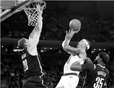  ?? NOAH K MURRAY-USA TODAY SPORTS/REUTERS ?? A New York Knicks player shoots the ball between Brooklyn Nets centre and Brooklyn Nets forward at Madison Square Garden