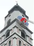  ?? FOTO: ULRICH STOCK ?? Auf einer Hebebühne, die bis auf 57 Meter Höhe ausgefahre­n werden kann, untersuche­n Mitarbeite­r eines Gutachterb­üros – von Schirmen gegen Regen geschützt – das Mauerwerk des Kirchturms.