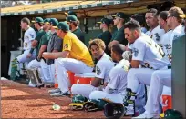  ?? Jose Carlos Fajardo
/ Bay Area News Group ?? The Oakland Athletics sit in the dugout as they watch the final out of their game against the Los Angeles Angels in the ninth inning of their MLB game at the Coliseum in Oakland on Sunday. The Los Angeles Angels defeated the Oakland Athletics 4-1.