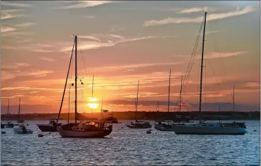  ?? TIM MARTIN/THE DAY ?? The sun sets on boats anchored Wednesday in Watch Hill Cove in Westerly.