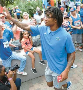  ?? BRAD MCCLENNY/GAINESVILL­E SUN ?? Florida quarterbac­k Anthony Richardson high-fives a young fan during the Gator Walk before the Gators’ April 14 spring game in Gainesvill­e.