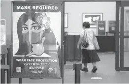  ?? CALEB JONES/AP 2020 ?? A woman walks into the internatio­nal airport in Honolulu. Hawaii officials are facing pressure to increase COVID-19 testing for travelers to the islands.