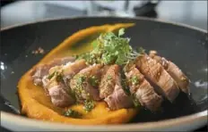  ??  ?? Pan-seared duck breast with brown butter carrot puree, crispy lentils, chermoula and walnut pistou.