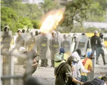  ?? AP ?? Manifestan­te arroja una bomba de gasolina a guardias.