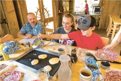  ?? PATRICK CONNOLLY/ORLANDO SENTINEL ?? State park resident volunteers, Tim Lugar, from left, Kyrah Lewis and Jedidiah Lewis experience the reopened Old Sugar Mill Pancake House in De Leon Springs State Park on Monday.