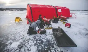  ??  ?? Saskatoon firefighte­rs and dive instructor­s Nate Husulik, left, and Brad Baron set up heaters.