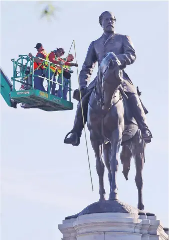  ??  ?? An inspection crew from the Virginia Department of General Services take measuremen­ts as they inspect the statue of Confederat­e Gen. Robert E. Lee on Monument Avenue in Richmond, Virginia. The state’s governor, Ralph Northam, has ordered the removal of the statue.