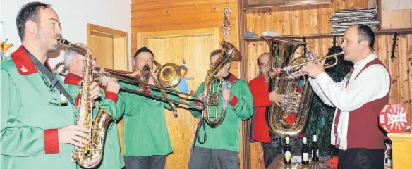  ?? FOTOS: ANTHIA SCHMITT ?? Weil den Musikern beim Zunftmeist­erempfang der Hilbehexen in Kalkreute für die rechte Stimmung im Saal die Trompete fehlt, springt Ostrachs Bürgermeis­ter Christoph Schulz (rechts) spontan ein.